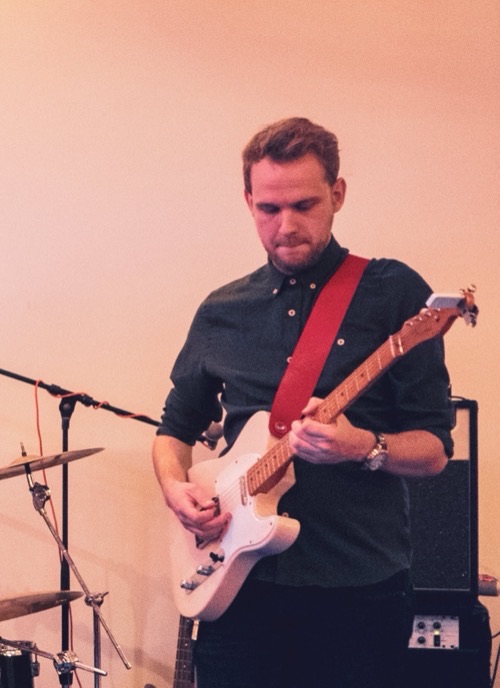 Playing an electric guitar at an indoor gig